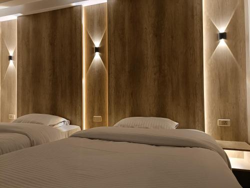 Sheraton Ocean 506 - Private apartments في القاهرة: ثلاثة أسرة في غرفة نوم مع جدران خشبية