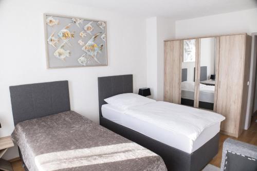 a small bedroom with two beds and a mirror at T&K Apartments near Messe Fair Trade Düsseldorf und Airport 1B in Duisburg