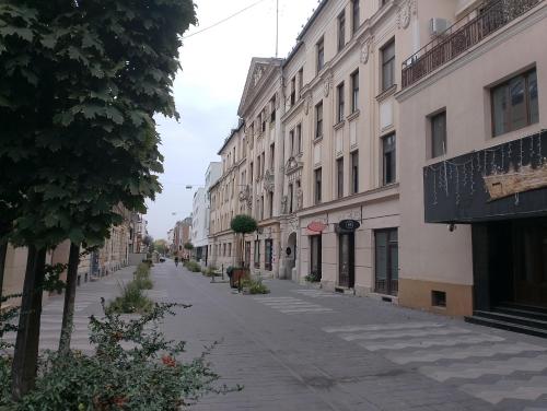 an empty street in a city with buildings at City Center Apartment Debrecen in Debrecen