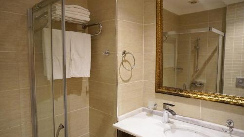 La salle de bains est pourvue d'un lavabo et d'une douche avec un miroir. dans l'établissement Vois Hotel Atasehir & SPA, à Istanbul