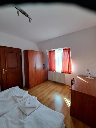 an empty room with a bed and a window at Penzión pri rybníku in Veľká Paka
