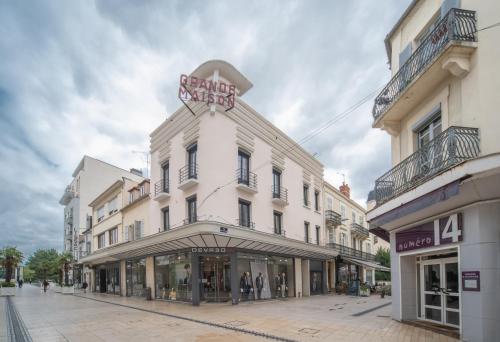 a white building with a sign on top of it at Grande Maison Vichy - Maison ou Appartements en Centre ville in Vichy