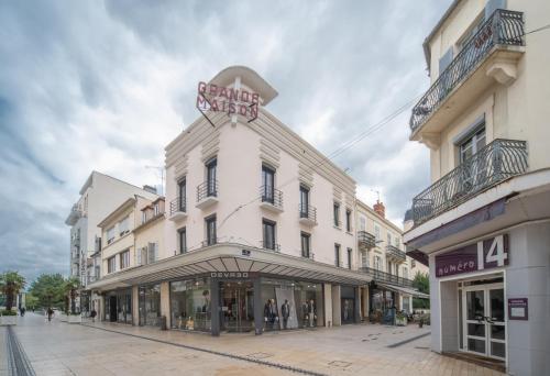 Un bâtiment blanc avec un panneau en haut dans l'établissement Grande Maison Vichy - Maison ou Appartements en Centre ville, à Vichy