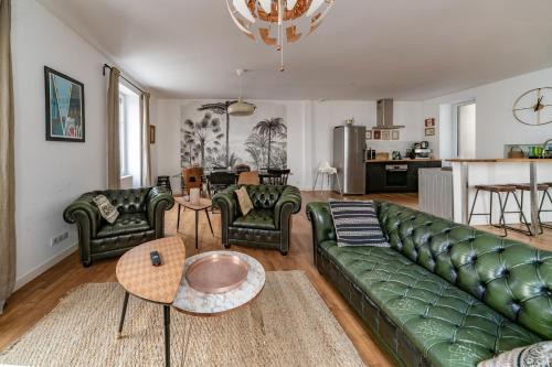 - un salon avec un canapé vert et des chaises dans l'établissement Grande Maison Vichy - Maison ou Appartements en Centre ville, à Vichy