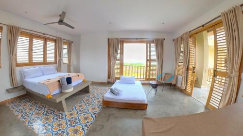 a bedroom with a bed and a room withwindows at Casa Mambo Salinas in Santa Veronica