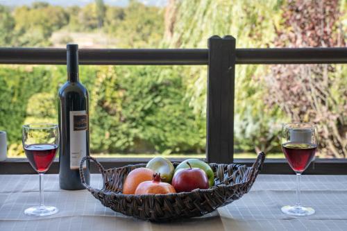 a basket of fruit and two glasses of wine on a table at Angel House Greystone Villa Polydrossos in Polydrossos
