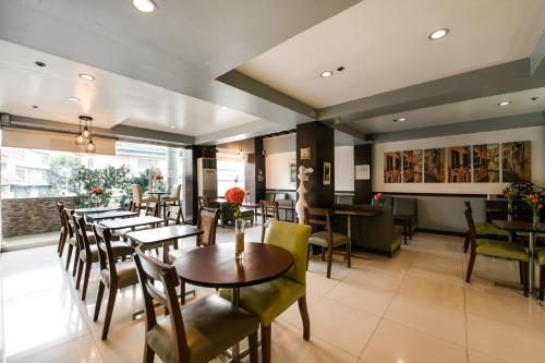 馬尼拉的住宿－Festive Hotel，餐厅内带桌椅的用餐室