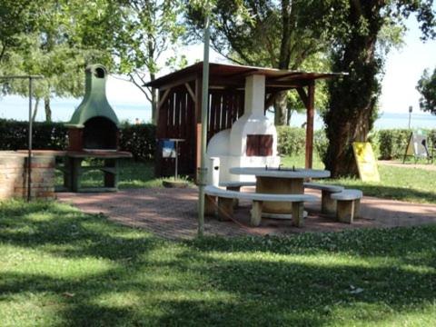 a picnic table and a bench in a park at Hotel Magistern Konferencia és WellnessHotel in Siófok
