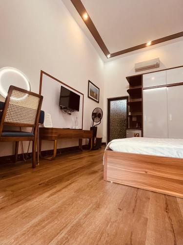 a bedroom with a bed and a desk with a television at Coto Center Homestay in Dao Co To