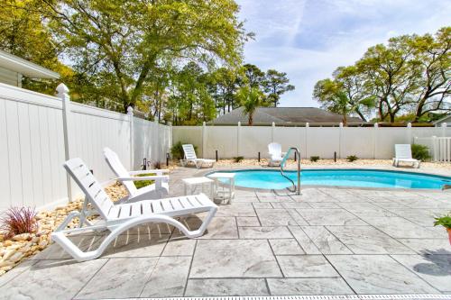 a patio with two chairs and a swimming pool at Ocean Isle Hidden Retreat in Ocean Isle Beach