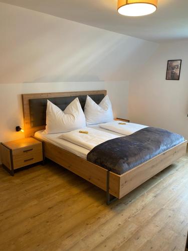 a bedroom with a large bed with white pillows at Apartment zum Bergkircherl - Sommercard in Großsölk