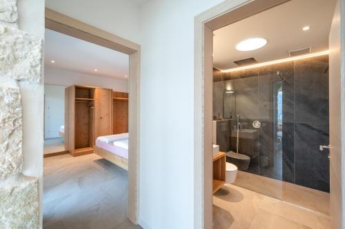 a bathroom with a glass door leading to a bedroom at Villa Ca' Stella Lake Garda in Brenzone sul Garda