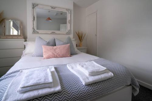 a bedroom with a bed with towels on it at Pass the Keys Cosy house with garden in Cheltenham