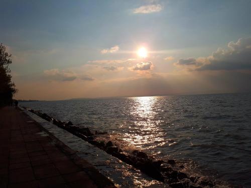a sunset over a body of water with the sun setting at Hotel Magistern Konferencia és WellnessHotel in Siófok