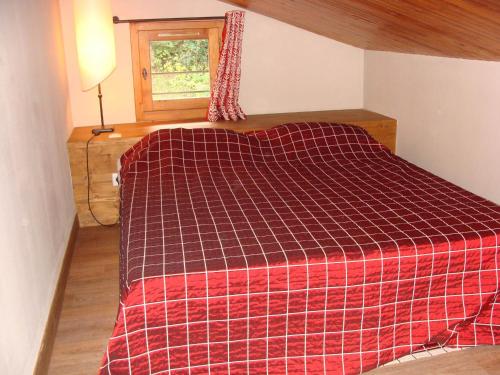 - une chambre avec un lit et une couverture rouge dans l'établissement Appartement spacieux proche centre village avec balcon et vue Mont Blanc - FR-1-181-2479, à La Plagne Tarentaise
