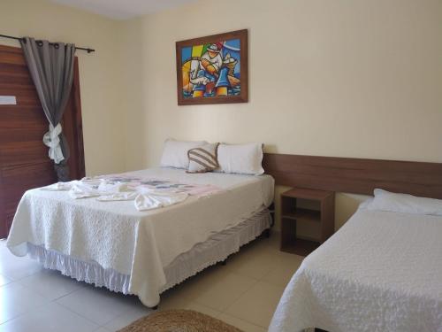 ein Schlafzimmer mit 2 Betten und einem Wandgemälde in der Unterkunft Pousada Beira Rio Parnaíba in Parnaíba