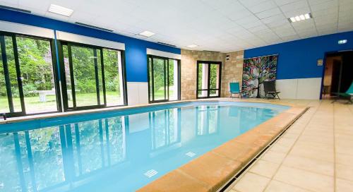 una gran piscina con paredes y ventanas azules en Hôtel-restaurant Le Tulipier en Vienne-le-Château
