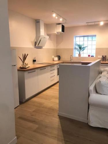 a kitchen with white cabinets and a white couch at T2 COSY AU COEUR DE MONTELIMAR in Montélimar