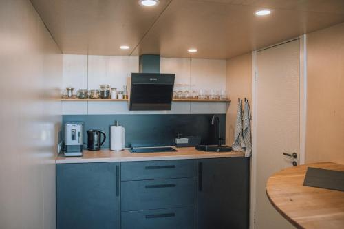 a kitchen with blue cabinets and a counter top at PullanHouse Līksma - small and cosy lakeside holiday house in Alūksne