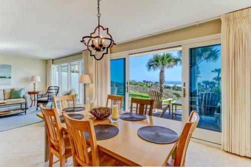 a dining room and living room with a table and chairs at Captains Court 1004 in Fernandina Beach