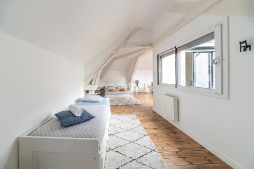 une chambre blanche avec un lit et une fenêtre dans l'établissement Grande Maison Vichy - Maison ou Appartements en Centre ville, à Vichy
