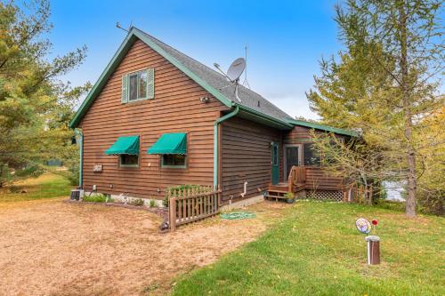 a house with green awnings on the side of it at RTLCMP Lakehouse in Arbor Vitae