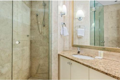 a bathroom with a shower and a sink and a mirror at CBD Corporate Apartment BON002810 in Sydney