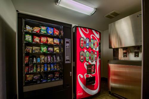 a red soda machine in a kitchen next to a refrigerator at Red Roof Inn Batavia in Batavia