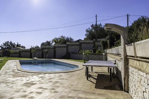 a swimming pool with a table next to a fence at Villa Romeo - Etna gateway in Piedimonte Etneo