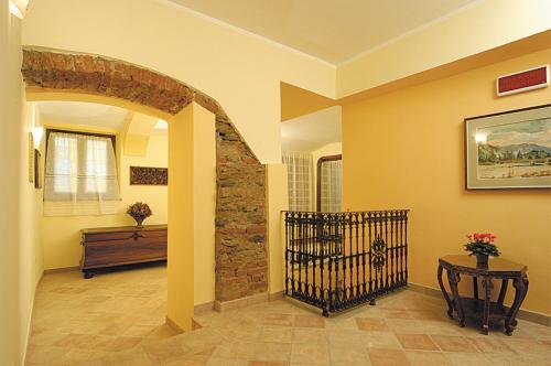 un corridoio con un pilastro in pietra e un tavolo con fiori di Casa Vacanze Provenzale a Torre Pellice