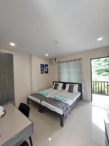 a bedroom with a bed and a table in it at Avila's Horizon Dive Resort Malapascua in Malapascua Island