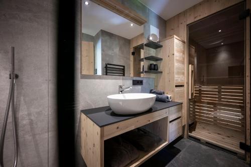 a bathroom with a white sink and a shower at Stelza Nature Chalet in Val di Vizze