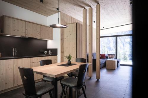 a kitchen and dining room with a wooden table and chairs at Stelza Nature Chalet in Val di Vizze