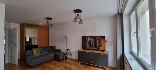 sala de estar con sofá y TV en Przytulnie w samym centrum Warszawy, en Varsovia