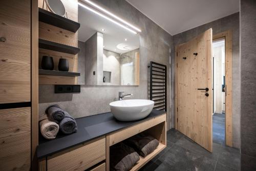 a bathroom with a white sink and a mirror at Stelza Nature Chalet in Val di Vizze