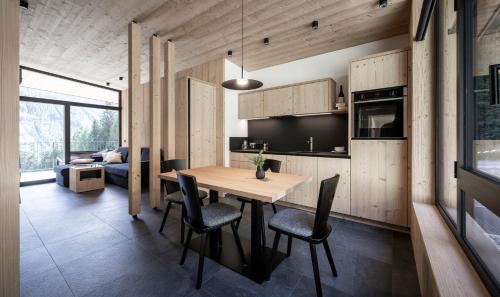 a kitchen and dining room with a wooden table and chairs at Stelza Nature Chalet in Val di Vizze