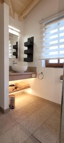 ein Bad mit einem Waschbecken und einem Spiegel in der Unterkunft Hochalmbahnen Chalets Rauris 1-18, Maislaufeldweg 1t in Rauris