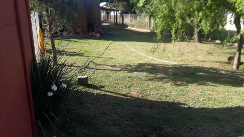 un patio con una manguera de jardín en el césped en casa de campo a 40 km de Rosario 