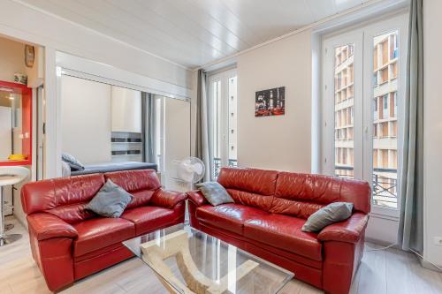 - un salon avec un canapé en cuir rouge dans l'établissement superbe Loft T2 13005, à Marseille