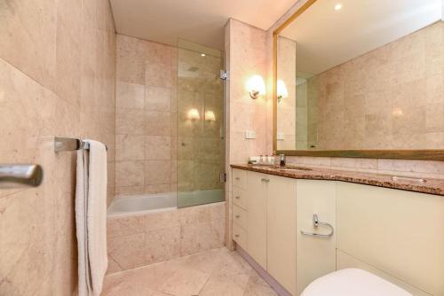 y baño con ducha, aseo y bañera. en Huge Exec Apartment -Fantastic CBD Location B21001 en Sídney