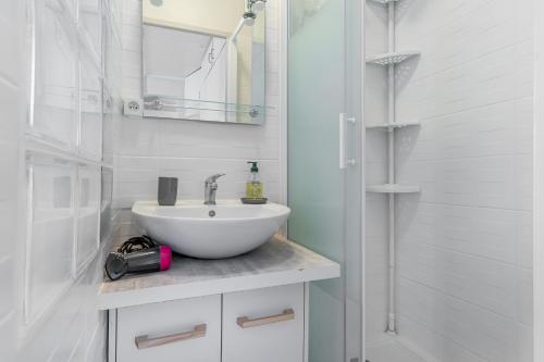 une salle de bain blanche avec un lavabo et une douche dans l'établissement superbe Loft T2 13005, à Marseille