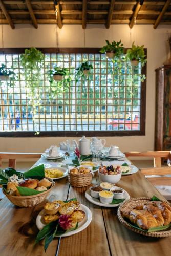 a wooden table with plates of food on it at DA GRAÇA HOTEL in Trancoso
