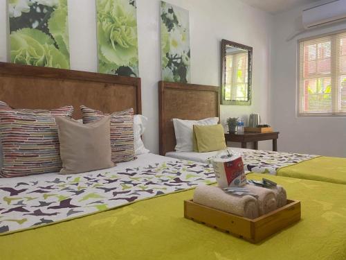 - une chambre avec 2 lits avec des draps verts et blancs dans l'établissement Pensio de Felipe, à Tagaytay