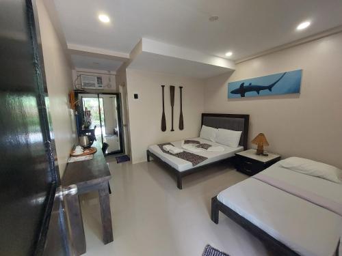 a large bedroom with two beds and a window at Avila's Horizon Dive Resort Malapascua in Malapascua Island