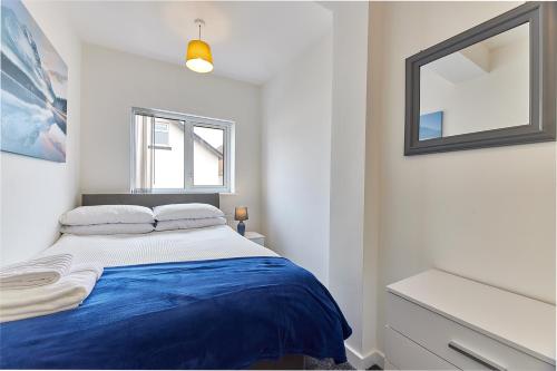 a white bedroom with a blue bed and a mirror at Gatacre House - Stylish 3 bed house, sleeps 7 in Blythe