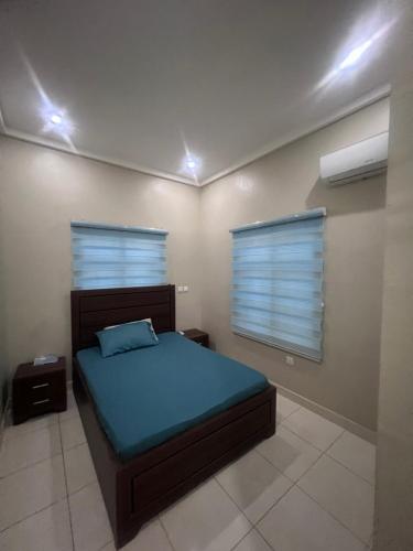 a bedroom with a bed and a window with blinds at Exquisite 2 bedroom apartment in Abuja