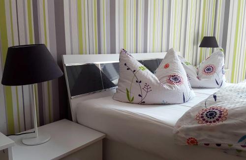a bed with white pillows and a lamp on a table at Ferienhaus Familie Knoll in Trautenstein