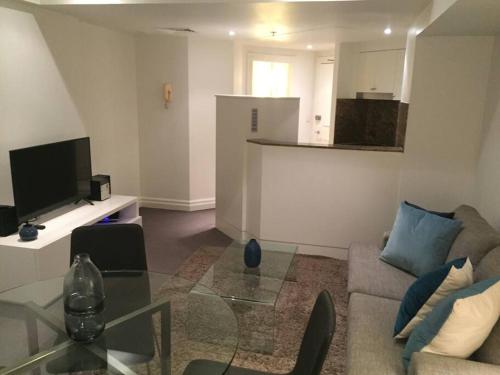 a living room with a couch and a glass table at Heart of SYDNEY CBD - studio apartment B412 in Sydney
