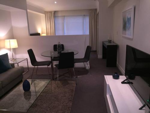 a living room with a couch and a table at Heart of SYDNEY CBD - studio apartment B412 in Sydney