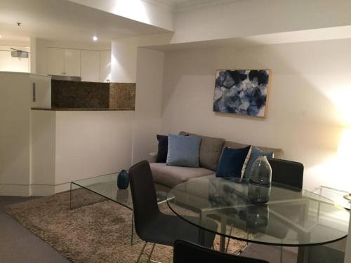 a living room with a couch and a glass table at Heart of SYDNEY CBD - studio apartment B412 in Sydney